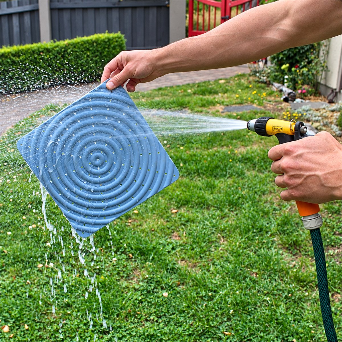 Rinsing a nesting pad clean with a garden hose